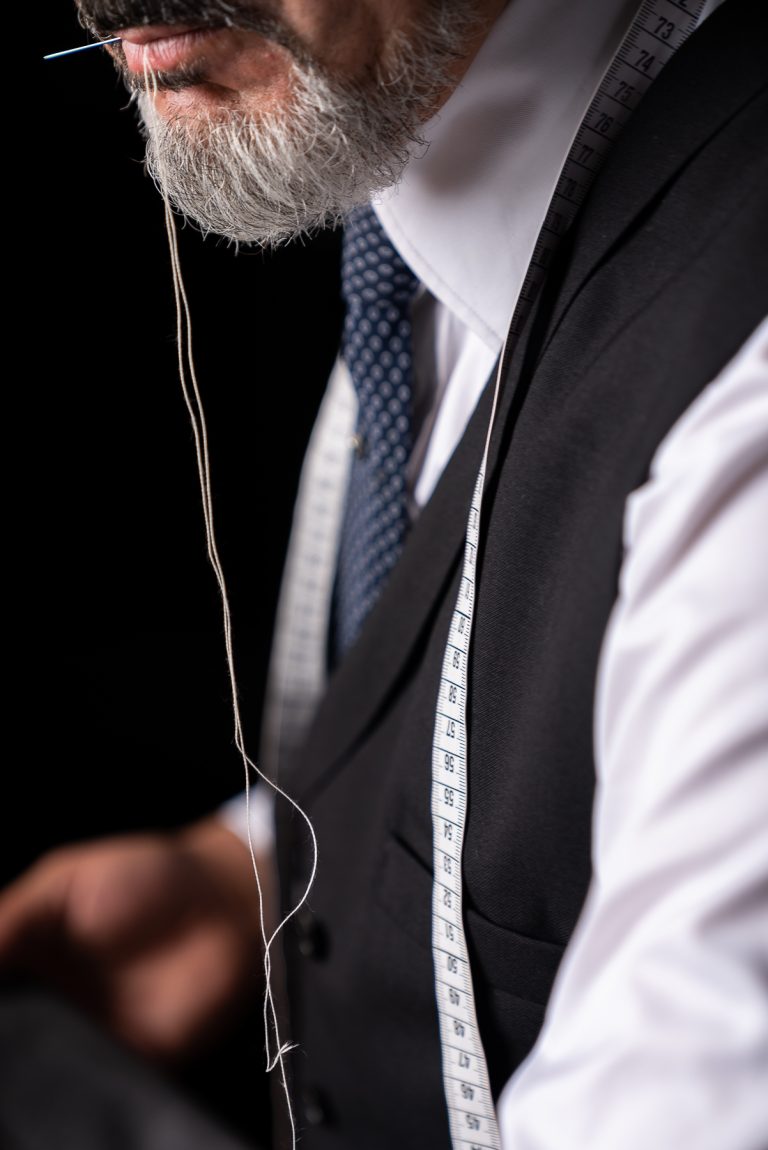 Portraitfoto von einem Herrenschneider vor schwarzem Hintergrund - Moritz Lüdtke Photography
